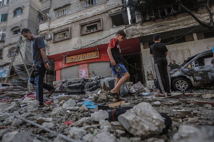 19 May 2021, Palestinian Territories, Gaza City: Palestinians inspect the remains of a destroyed residential building, after it was hit by Israeli airstrikes, amid the escalating flare-up of Israeli-Palestinian violence. According to the Palestinian aut
