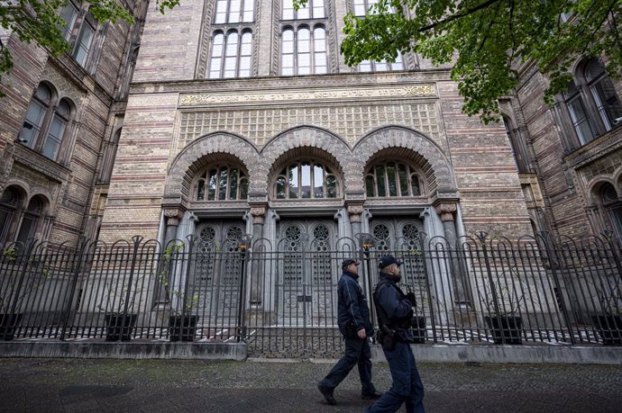 14 May 2021, Berlin: Two policemen walk past the entrance to the New Synagogue Berlin. Photo: Fabian Sommer/dpa