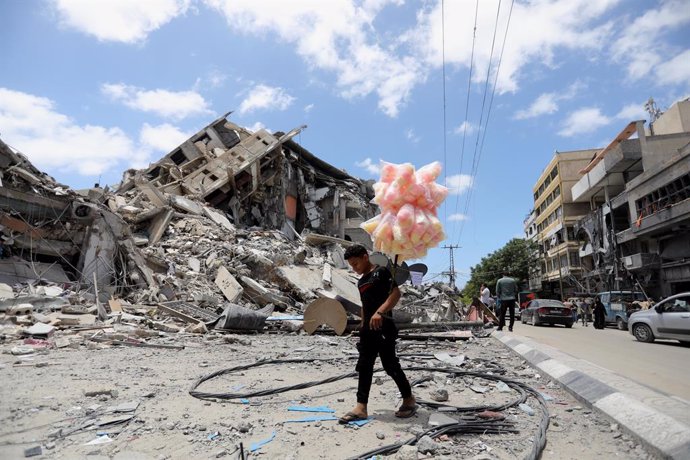 22 May 2021, Palestinian Territories, Gaza: A Palestinian vendor walks past by the ruins of a destroyed building following the Egypt-brokered ceasefire agreement between the Israeli government and the Palestinian Hamas Islamist movement. Photo: Ashraf A