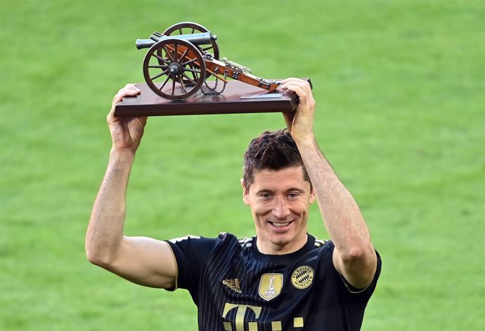 22 May 2021, Bavaria, Munich: Munich's Robert Lewandowski receives the trophy of the top goalscorer of the season after the final whistle of the German Bundesliga soccer match between FC Bayern Munich and FC Augsburg at Allianz Arena. Photo: Sven Hoppe/