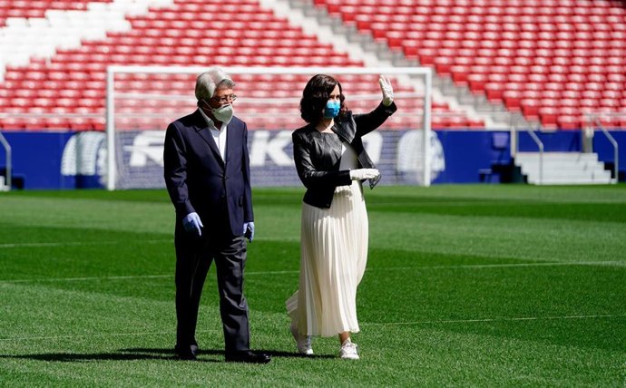 Archivo - La presidenta de la Comunidad de Madrid, Isabel Díaz Ayuso, acompañada por el presidente del Atlético de Madrid, Enrique Cerezo, pasea por el campo del Wanda Metropolitano durante su visita a sus instalaciones, en una imagen de archivo