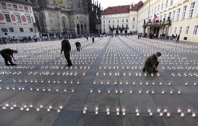 10 May 2021, Czech Republic, Prague: People and Soldiers light candles in the courtyards of Prague Castle, during a commemoration for victims of the coronavirus pandemic. Photo: íhová Michaela/CTK/dpa