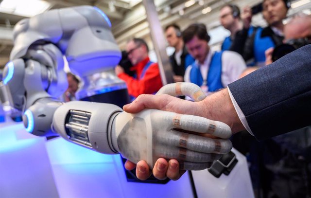 Archivo - Un robot estrecha la mano de una persona en Hanóver, Alemania