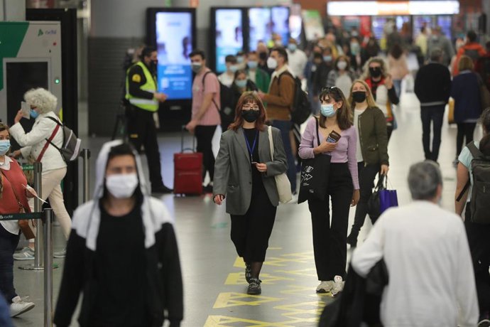 Varias personas caminan con su equipaje por la estación de Madrid - Puerta de Atocha, a 14 de mayo de 2021, en Madrid (España).