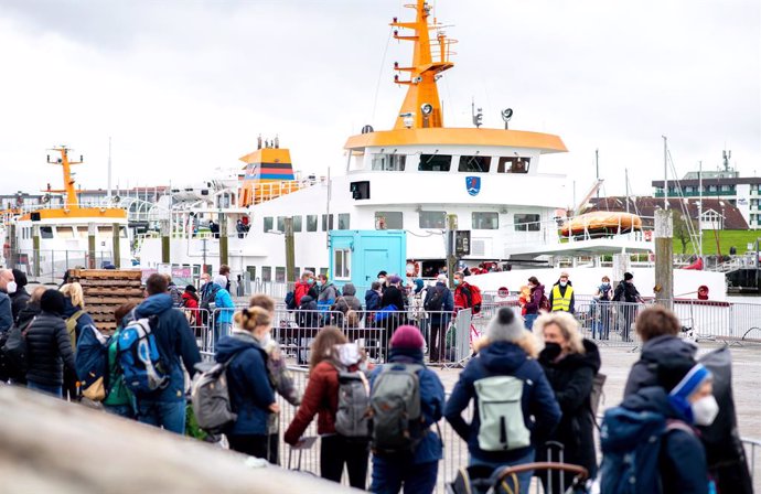 22 May 2021, Lower Saxony, Bensersiel: Numerous tourists wait at the ferry port before crossing to the island of Langeoog to boarda a ferry. Photo: Hauke-Christian Dittrich/dpa
