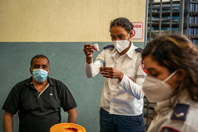 Archivo - Militares israelíes vacunando a un trabajador palestino