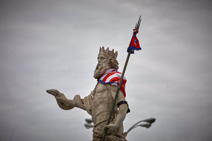 La estatua de la fuente de Neptuno, con una bufanda del Atlético de Madrid, a 23 de mayo de 2021, en Madrid (España). Esta bufanda en la estatua de Neptuno es resultado de las celebraciones, durante la noche de este sábado, por la victoria del club roji