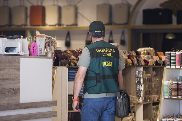 Un agente de la UCO vigila en uno de los registros realizados a establecimientos del polígono industrial de Cobo Calleja, a 24 de mayo de 2021, en Fuenlabrada, Madrid (España)