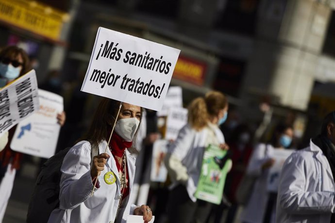 Archivo - Una trabajadora sanitaria sostiene un cartel donde se puede leer "Más sanitarios mejor tratados" durante una concentración convocada por la Asociación de Médicos y Titulados Superiores de Madrid (AMYTS), en la Puerta del Sol, en Madrid (España