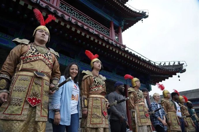 Foreign friends taking photos with popular warriors in golden armor at the city wall of Xian