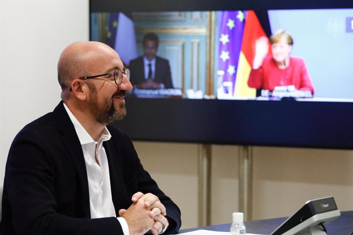 HANDOUT - 21 May 2021, Belgium, Brussels: European Council President Charles Michel (L) speaks with French President Emmanuel Macron (C) and German Chancellor Angela Merkel (R) during a video conference meeting with other several EU leaders at the Europ