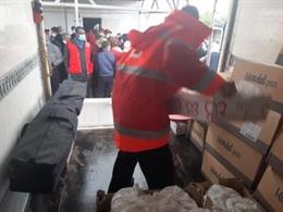 Un voluntario reparte productos de primera necesidad entre los afectados en el incendio de Níjar