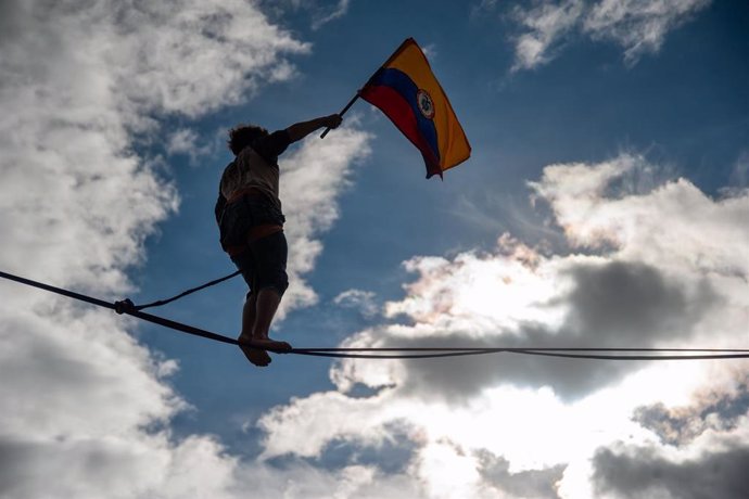 Un manifestante camina sobre la cuerda floja mientras agita la bandera colombiana en el estadio de fútbol El Campín durante una manifestación contra el Gobierno del presidente Iván Duque.