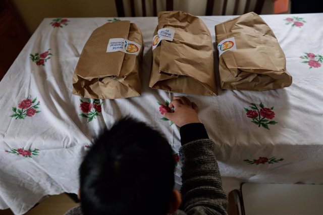 Archivo - Un niño durante la comida en su casa antes de abrir el menú de la ONG del chef José Andrés, durante la pandemia.
