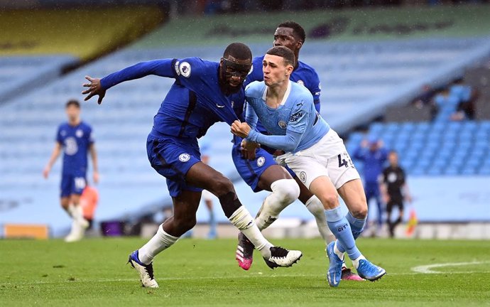 08 May 2021, United Kingdom, Manchester: Manchester City's Phil Foden pulls on the shirt of Chelsea's Antonio Rudiger as they battle for position during the English Premier League soccer match between Manchester City and Chelsea at the Etihad Stadium. P