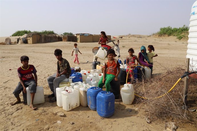 Archivo - Niños esperan para llenar bidones de agua en Yemen