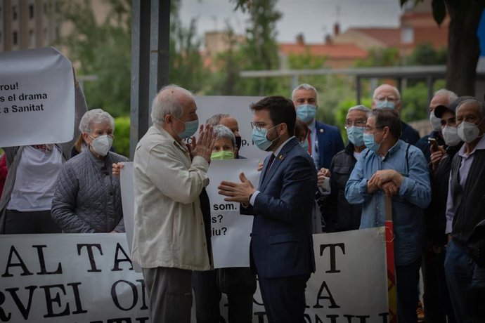 El presidente de la Generalitat Pere Aragons (d) conversa con un vecino durante una concentración por la sanidad "100% pública" antes de su visita al Hospital Parc Taulí un día después de tomar posesión de su cargo
