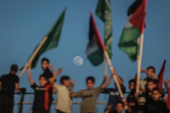 24 May 2021, Palestinian Territories, Gaza City: Supporters of the Palestinian Hamas Islamist movement hold flags during a rally by Hamas military wing 'Izz ad-Din al-Qassam Brigades' to commemorate the martyrs of the last battle between Hamas and Israe