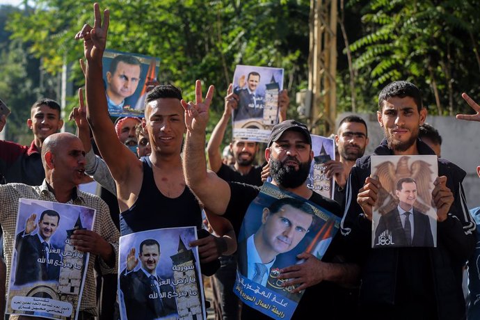20 May 2021, Lebanon, Baabda: Syrians carry pictures of Syrian President Bashar al-Assad while heading to cast their votes during the first stage of the Syrian Presidential election at the Syrian Embassy. Photo: Marwan Naamani/dpa