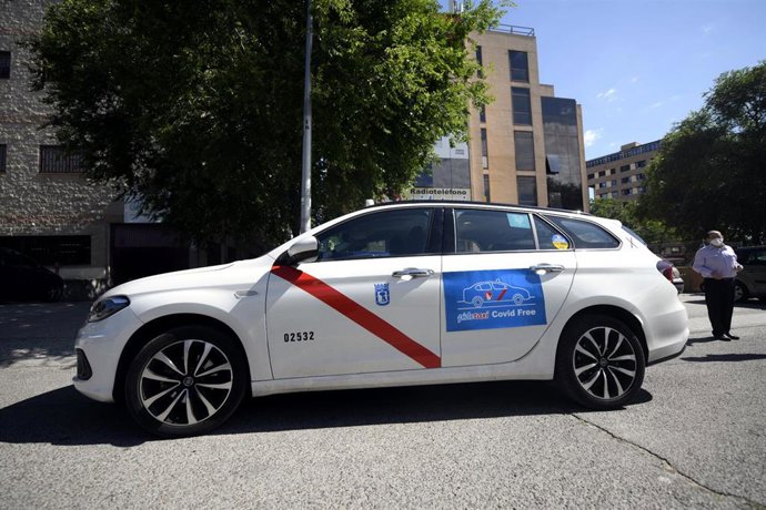 Archivo - Un taxi estacionado en una calle de la capital con un cartel de Covid-Free.