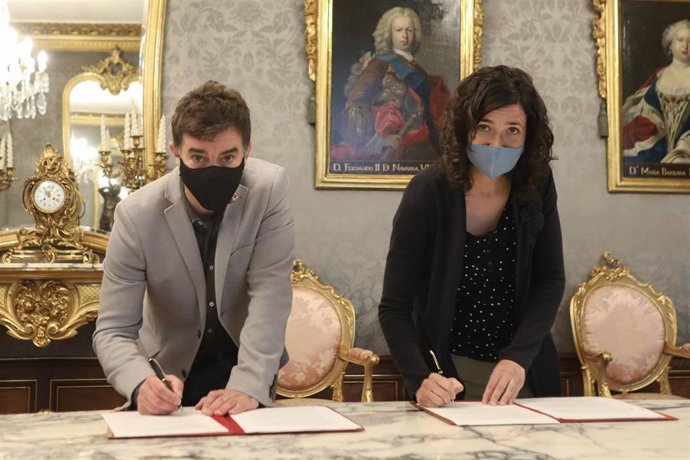 El consejero de Politicas Migratorias y Justicia del Gobierno de Navarra, Eduardo Santos, y la presidenta de SOS Racismo Navarra, Miriam Irisarri, firman un convenio.