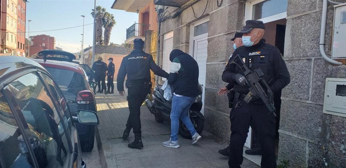 Agentes de Policía Nacional trasladan a un detenido en el marco de un operativo contra el tráfico de drogas, en el que se realizaron 10 arrestos y varios registros en Vigo, Poio y Pontevedra.
