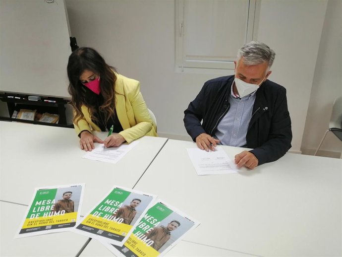 La presidenta de los hosteleros, María Jesús Herández, y el presidente de la AECC, Artemio Domínguez, firman el convenio.