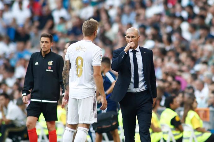 Archivo - Zinedine Zidane habla con Toni Kroos en un Real Madrid-Real Valladolid del 24 de agosto de 2019