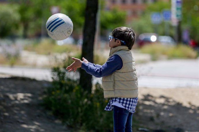 Archivo - Un niño con síndrome de Down juega con una pelota.