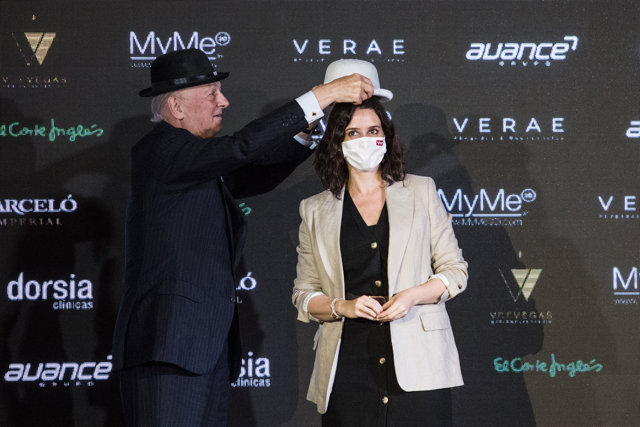 El empresario Pelayo de la Mata (i) le coloca un bombín a la presidenta en funciones de la Comunidad de Madrid, Isabel Díaz Ayuso, (d) durante el acto de entrega de los Premios Bombines de San Isidro 2021