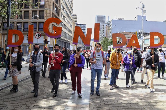 26 May 2021, Colombia, Bogota: Young protesters carry letters forming the word "dignity" during a demonstration against the government of President Ivan Duque Marquez. Photo: Camila Díaz/colprensa/dpa