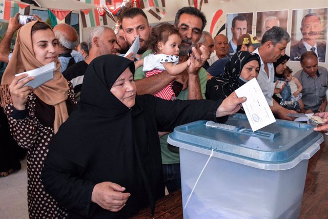HANDOUT - 26 May 2021, Syria, Homs: A picture provided by the Syrian Arab News Agency (SANA) shows a woman casting her ballot at a polling station during the Syrian presidential election. Photo: -/SANA/dpa - ATTENTION: editorial use only and only if th