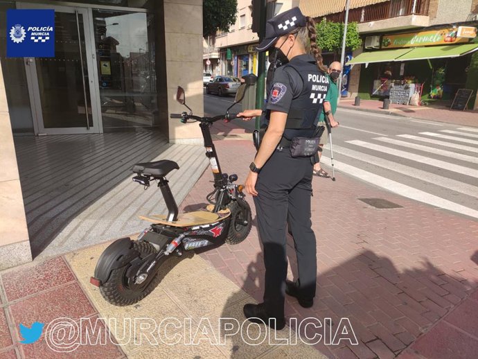 Una agente de Policía Local, con el vehículo eléctrico