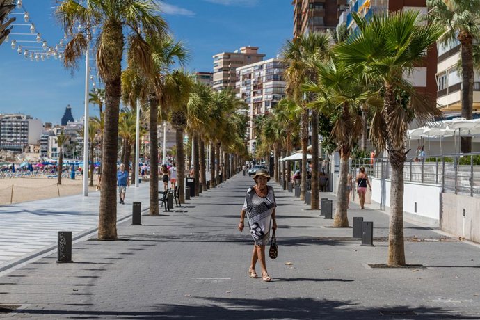 Archivo - Una mujer pasea por el paseo marítimo de Benidorm durante el Día Mundial del Turismo 2020