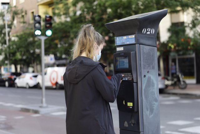 Una joven utiliza un parquímetro del Servicio de Estacionamiento Regulado (SER) de Madrid 
