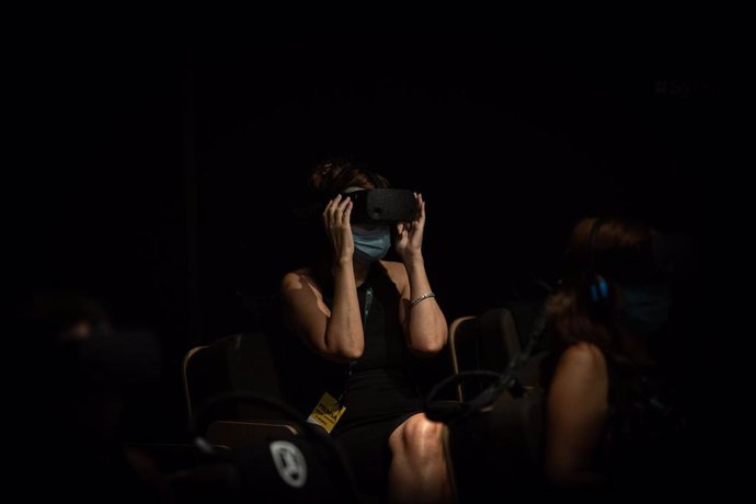 Archivo - Una mujer observa por unas gafas de realidad virtual el filme inmersivo Symphony en CosmoCaixa, Barcelona, Catalunya (España), a 15 de septiembre de 2020