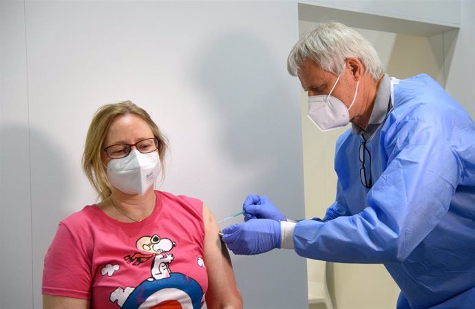 27 May 2021, Brandenburg, Potsdam: Doctor Christoph Borch gives a woman a shot of a Coronavirus vaccine at the Babelsberg Vaccination Center in the Metropolishalle. Beforehand, the Digital Vaccination Card was presented during a press event. Experience 
