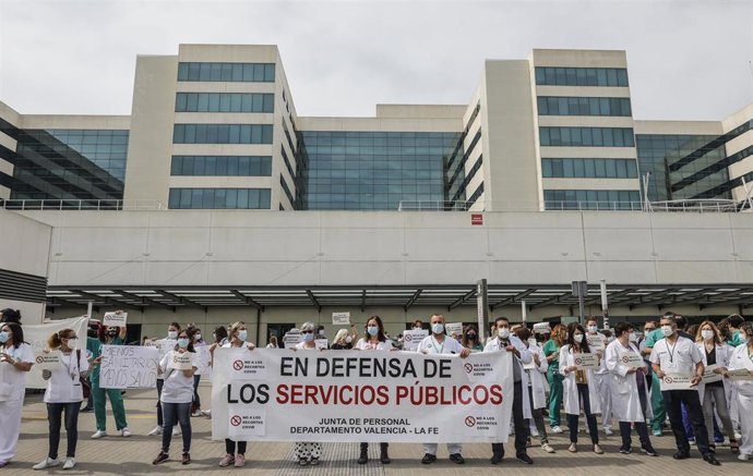 Varias personas de Juntas de Personal de departamentos de Salud con una pancarta en la que se lee: "En defensa de los servicios públicos", durante una concentración contra el cese de los contratos refuerzo Covid, en la puerta del Hospital de La Fe. 