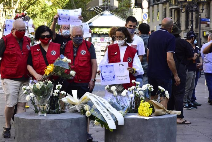 Archivo - Asistentes dejan rosas blancas y carteles en recuerdo a las 16 personas fallecidas el 17 de agosto de 2017 y a los más de 150 heridos en los atentados de Barcelona y Cambrils durante el homenaje celebrado en Las Ramblas con motivo del tercer a