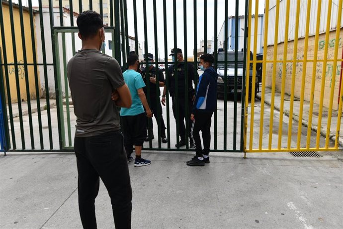 Varios ciudadanos de Ceuta llevan a un menor que se han encontrado por la calle al punto de acceso a las naves de menores del Tarajal durante una jornada tranquila en Ceuta, a 21 de mayo de 2021, en Ceuta (España).