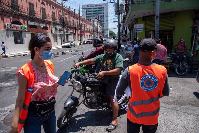 Trabajadores de la Comisión Permanente de Contingencias realizan labores de prevención del coronavirus en San Pedro Sula.