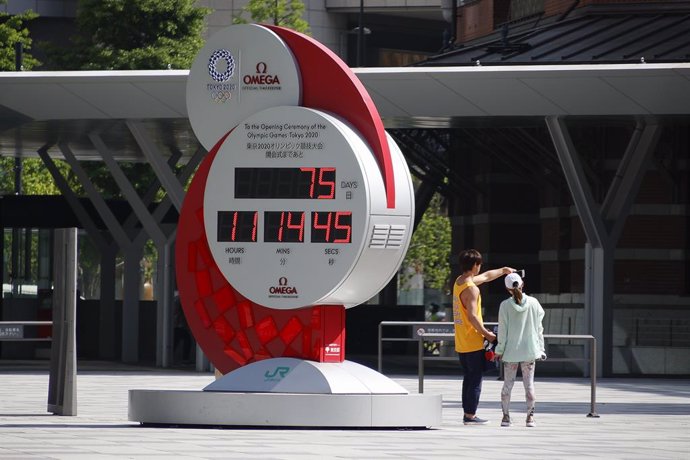 09 May 2021, Japan, Tokyo: People take a photo near Tokyo 2020 Olympic Games countdown clock outside Tokyo station. Tokyo reported 1,121 new cases of coronavirus (COVID-19) on Saturday, the highest number since 22 January 2021. On Friday, Japan's Prime 