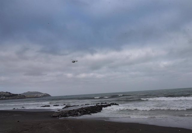 Archivo - Un helicóptero sobrevuela la zona en la que Salvamento Marítimo colabora en la recogida de migrantes en las aguas de Ceuta, en una imagen de archivo