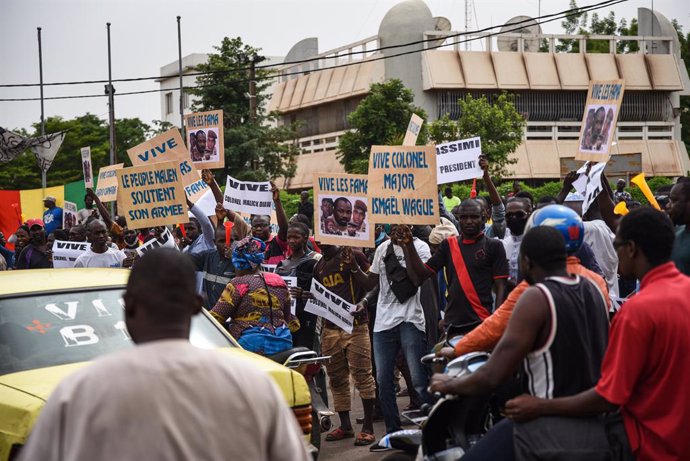 28 May 2021, Mali, Bamako: Supporters of Malian Armed Forces (FAMA) hold placards during a protest at Independence square in Bamako, against the expense of current French policy and to celebrate the recent coup led by the vice president of the transitio