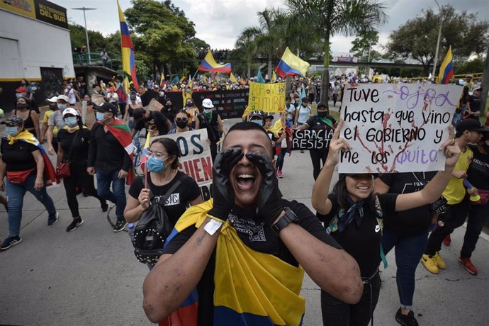 Manifestantes gritan consignas contra el Gobierno al pasar frente a la Universidad Santiago de Cali durante una protesta contra la Administración de Iván Duque.