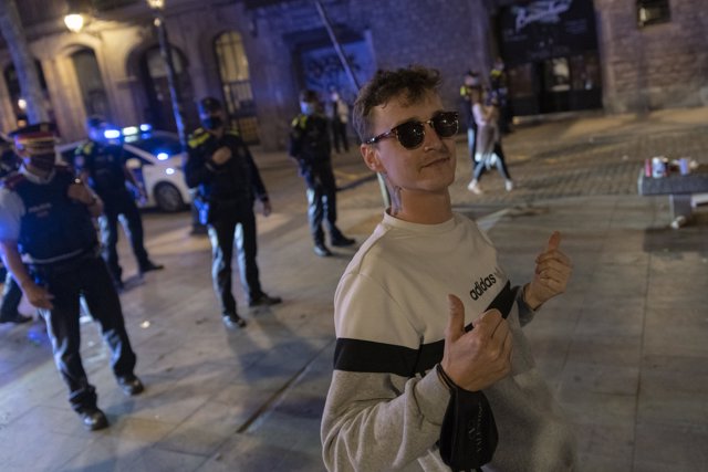 Un joven, frente a un grupo de policías, a 22 de mayo de 2021, en Barcelona, Catalunya (España).