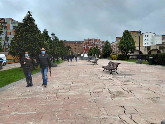 Personas paseando por La Losa de Oviedo en un día de primavera, con mascarillas.