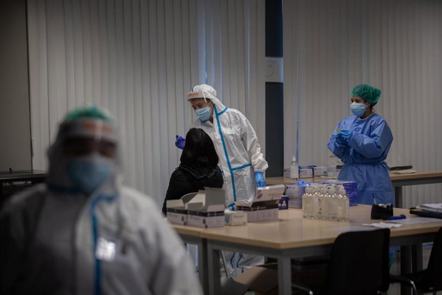 Archivo - Una mujer recibe una prueba PCR.