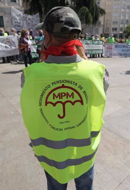 Una persona acude con un chaleco del Movimiento Pensionista de Madrid durante una concentración