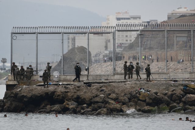 Varios militares del ejército español vigilan durante las devoluciones en caliente que están efectuando a los migrantes que han entrado en Ceuta procedente de Marruecos, a 18 de mayo de 2021, en Ceuta, (España)